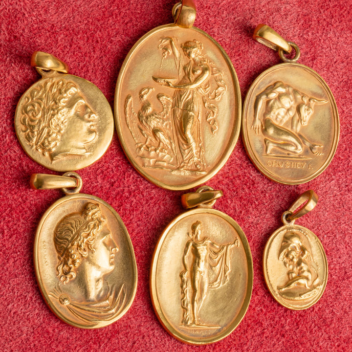 multiple pieces of 18k gold pendants on red felt